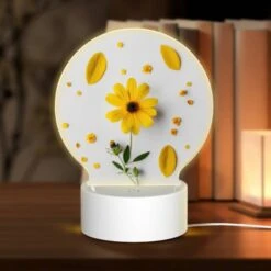 Round Acrylic Night Light, A Yellow Flower With Yellow Petals And Green Leaves Is Placed On A White Surface.