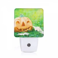Night Light, A Fake Pumpkin With A Smile On It Sits On The Grass.